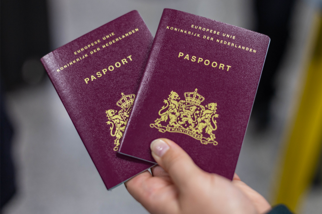 persoon die twee nederlandse paspoorten vasthoudt
